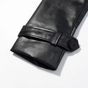 Detailed close-up of a black faux leather coat cuff featuring a buttoned strap and texture