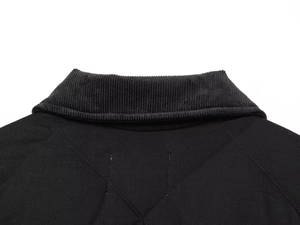 Détail du col en velours côtelé et matelassage en losanges sur veste de rue noire
