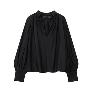 Detail of black V-neck blouse showing gathered neckline and puff sleeve cuffs