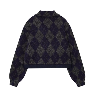 Macro detail of diamond argyle knit pattern on navy blue and grey bomber jacket