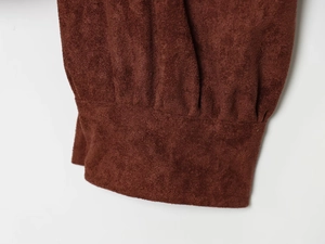 Detail of premium brown suede jacket featuring tight pleated cuff and matte texture
