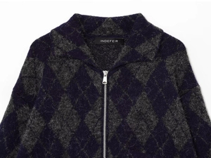 Detailed view of argyle knit collar with fuzzy texture and silver metallic zipper