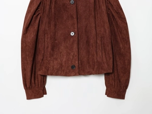 Close-up of deep brown faux suede jacket with puff sleeves and black button details