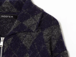 Detailed view of the diamond-patterned heavy knit bomber jacket with a silver metal zipper