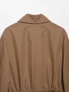 Detail of khaki brown parka jacket back showing twill fabric texture and elastic waist seam