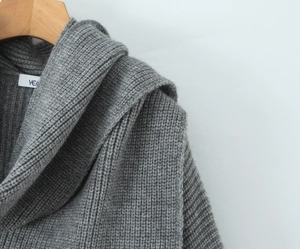 Detail of grey chunky knit sweater with ribbed texture and woven collar label