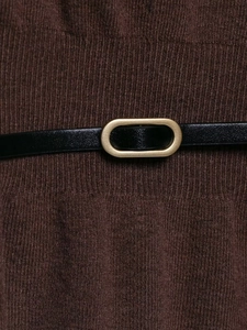 Close-up of brown knit sweater texture featuring a slim black belt with gold oval buckle
