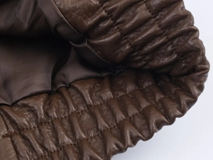 Détail d'une veste en similicuir marron avec ourlet élastique et doublure en soie lisse