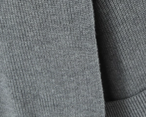 Detailed macro view of gray knitted fabric with professional ribbed texture patterns
