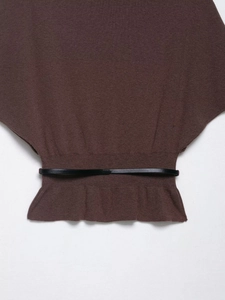 Detail of brown knit sweater featuring batwing sleeves and a thin black waist belt