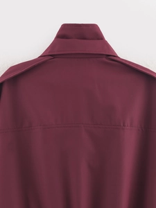 Détail du col arrière et des épaulettes décoratives sur une veste de couleur rouge foncé