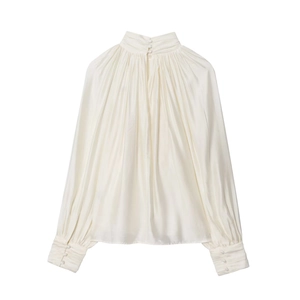 Close-up of pearl white satin shirt featuring pleated high neck and multi-button wide cuffs
