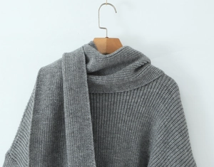 Detail of dark grey knit sweater texture with matching scarf on a wooden hanger