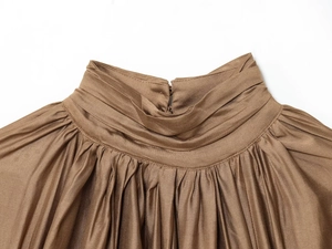 Detail of coffee satin blouse featuring elegant high neck draped pleats and silky texture