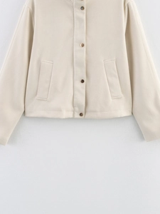 Détail de la veste en polaire crème avec col montant, boutons dorés et poches latérales