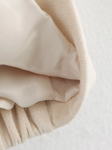 Détail de la veste beige montrant le tissu extérieur pelucheux et la doublure en satin