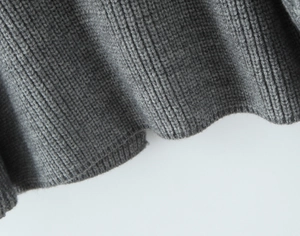 Detail of dark grey knit fabric showing fine ribbed texture and soft drape quality