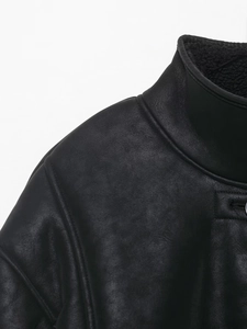 Détail de la veste en daim noir avec col montant épais et doublure chaude en fausse fourrure