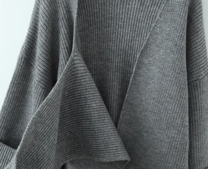 Detailed macro view of the grey ribbed knit fabric texture and soft wool material