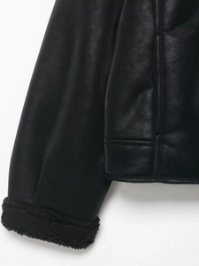 Détail des coutures d'une veste en similicuir avec finitions en polaire sherpa noire