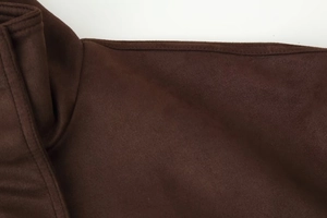 Detail view of dark brown suede jacket showing fine stitching and soft fabric texture