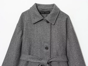 Close-up of lapel collar and brand label on a grey wool blend coat with dark buttons