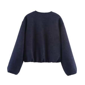 Detailed view of navy blue crewneck bomber jacket with elastic hem and soft texture