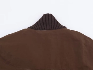 Detail of dark brown jacket featuring a knitted ribbed stand collar and premium texture