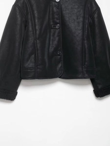 Détail d'une veste en daim noir avec doublure chaude en peau lainée et boutons classiques