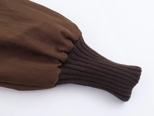 Detailed close-up of dark brown jacket sleeve with elastic ribbed knit windproof cuffs