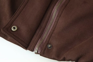 Detail of vintage copper zipper and star-embossed snap buttons on brown suede jacket