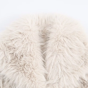 Detailed macro shot of warm beige faux fur collar on a street style winter jacket