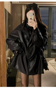 Detail of a chic black PU leather coat with double-breasted buttons and waist drawstring