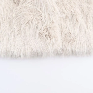 Close-up detail of soft light beige long-haired faux fur fabric for winter fashion jackets