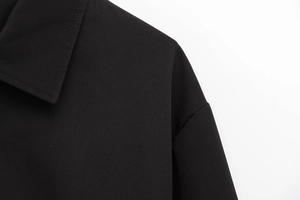 Dettaglio del colletto della giacca in twill nero con cuciture di precisione e design