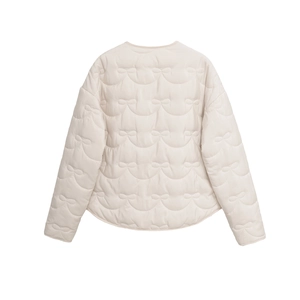 Detail view of the elegant beige quilted jacket showing unique bow-shaped stitching pattern