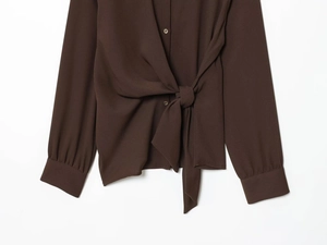 Détail de chemisier marron foncé en crêpe avec ourlet noué et poignets boutonnés