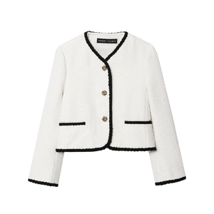 Detailed view of white tweed jacket featuring black woven trim and gold embossed buttons