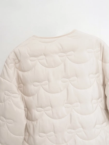 Detail of light beige quilted jacket showing unique ribbon and wave pattern stitching