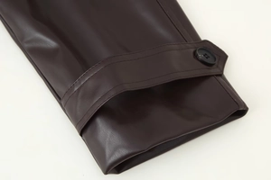 Détail du poignet d'un manteau en cuir PU prune avec bride réglable et bouton rond