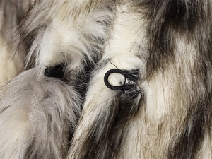 Nahaufnahme des schwarzen elastischen Schlaufenverschlusses an der Webpelzjacke