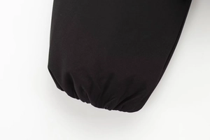 Dettaglio del polsino elastico sulla giacca streetwear nera con tessuto antivento