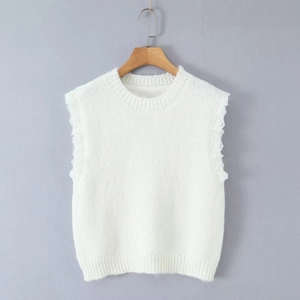 Detail of white knit vest featuring exquisite lace trim at the armholes and ribbed hem