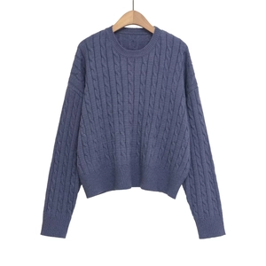 Detail shot of cable knit texture on blue long sleeve crewneck sweater