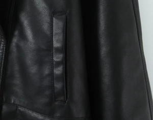 Detailed close-up of side pocket and premium leather texture on a black PU jacket