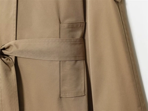 Detail of khaki trench coat waist belt and reinforced double-stitched belt loops