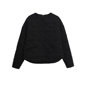 Detailed view of women's black quilted jacket with unique bow-tie stitching and snap buttons