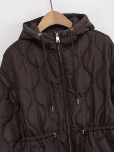 Detail of wave quilted brown jacket with waist drawstring and metallic hardware