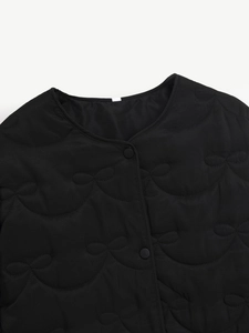 Detail of black quilted jacket showing the unique bow-pattern stitching and button closure