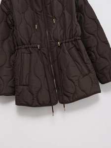 Detail of dark brown quilted lightweight jacket featuring adjustable waist drawstring and zipper